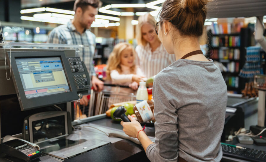Família parada no balcão enquanto vendedora os atende